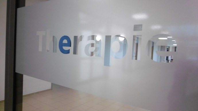 Schriftzug "Therapie" an der Glastür zum Therapie-Flur: das Glas ist matt, die Buchstaben sind durchsichtig. Schriftzug "Therapie" an der Glastür zum Therapie-Flur: das Glas ist matt, die Buchstaben sind durchsichtig.