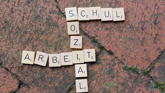 Scrabble-Buchstaben auf roten Pflastersteine bilden die Wörter "Schul" - "Sozial" - "Arbeit" Scrabble-Buchstaben auf roten Pflastersteine bilden die Wörter "Schul" - "Sozial" - "Arbeit"